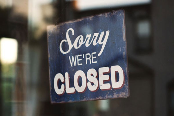 Sorry we're closed sign hanging in a window